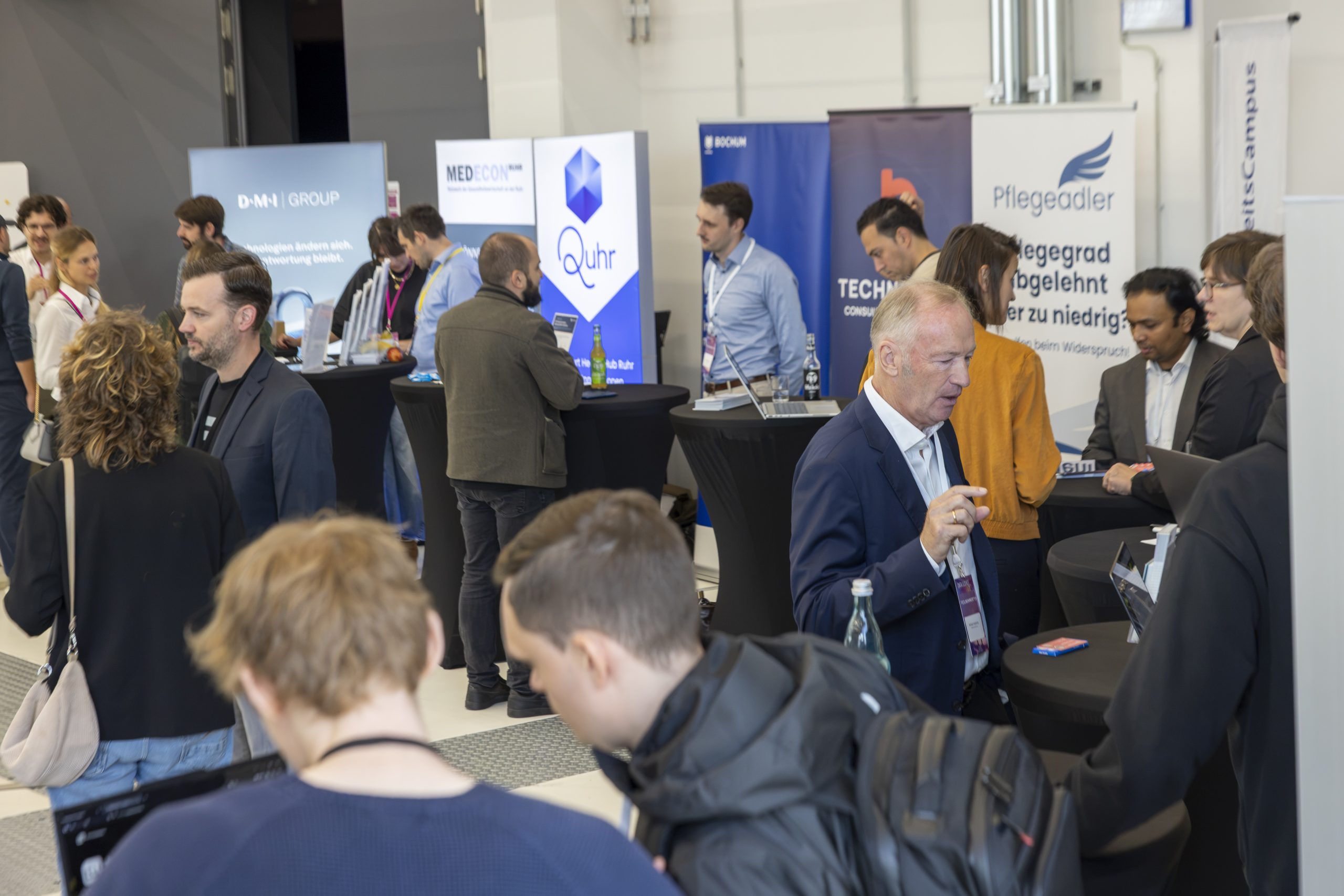 Besucher im Gespräch am Pflegeadler-Stand beim #DSRuhrgebiet Kongress in Bochum.